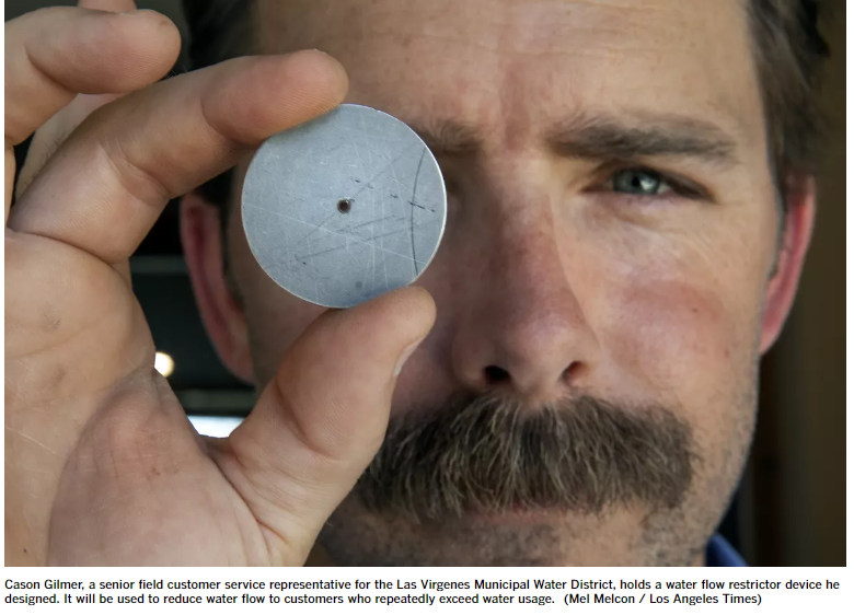 CAson Giler holds flow restricto up to his eye shoing how small the hole to let water thorugh is. Photo courtesy of the LA Times