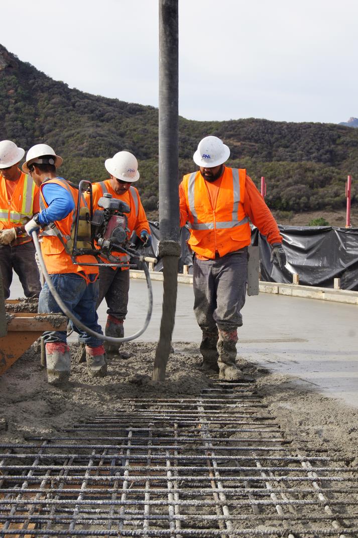 Crew filling rebar with the concrete through concrete snorkel