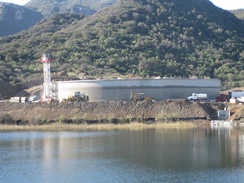 Workers continue installing the inlet/outlet pipelines that run between the new tank and the Filtration Plant. Here, slurry is being applied to cover and protect the new pipelines.