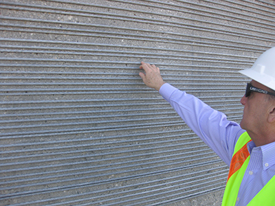 A workman demonstrates the 7/8 – inch diameter of the cables and how closely they are placed.