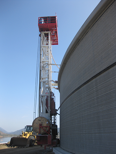 Installation tower circles the tank, wrapping it with thick steel cables, adding strength to the structure.