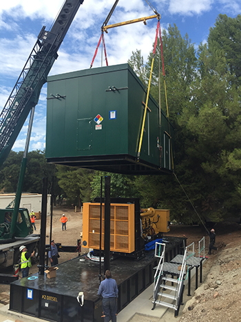 The generator’s protective housing being lowered into place